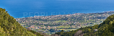 Buy stock photo Landscape of a coastal city between hills and mountains from above. A peaceful village beside calm blue ocean water in the Canary Islands. High angle view of Los Llanos, La Palma in summer