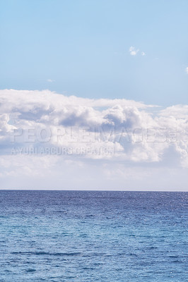 Buy stock photo A cloudy blue sky and peaceful, calm ocean separated by a beautiful horizon with copy space. Deep blue water underneath a cloudscape skyline. The many tides, currents and waves in the wide open sea