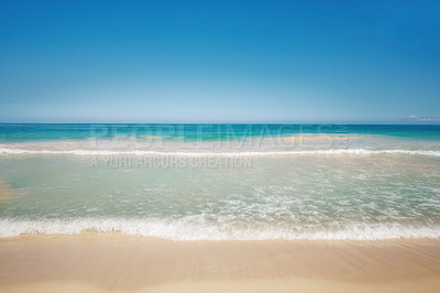 Buy stock photo Copy space at the sea with a clear blue sky background above the horizon. Calm ocean waters washing onto an empty beach shore. Peaceful scenic coastal landscape for a relaxing and zen summer getaway