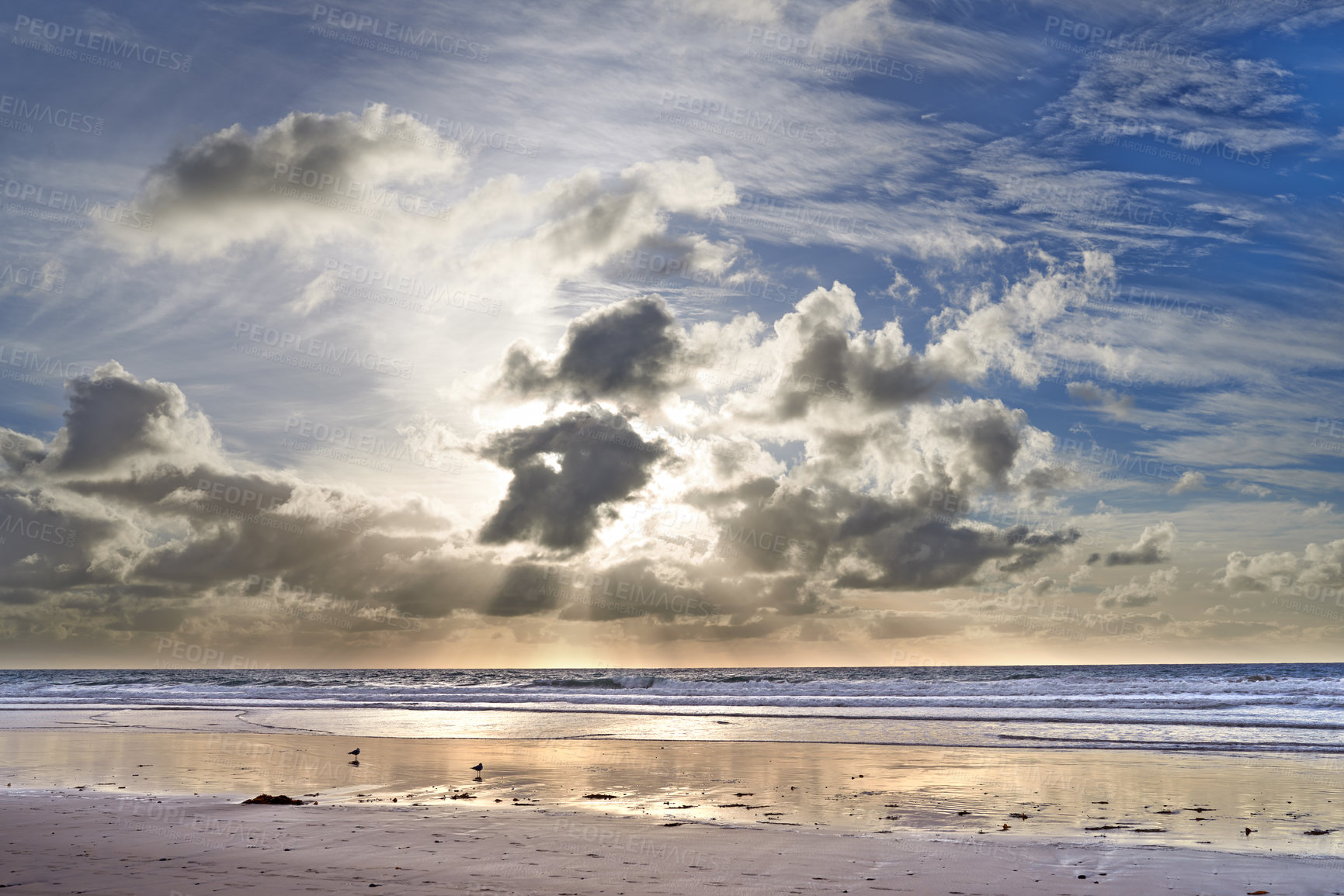 Buy stock photo Copy space at the sea with a cloudy blue sky background above the horizon. Calm ocean waters wash onto an empty beach shore. A peaceful scenic coastal landscape for a relaxing and zen summer getaway