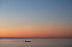 Cargo ship on calm sea after sunset
