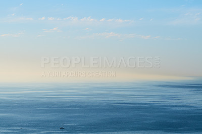 Buy stock photo An empty ocean with a blue sky and copy space. A wide open seascape background of a beach with calm water. Scenic sea surface with calming ripples and the rising morning sun on the horizon