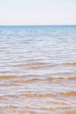 Buy stock photo Copy space at the sea with a clear blue sky background above the horizon. Calm ocean waters at an empty beach. Peaceful and scenic coastal landscape for a relaxing and zen summer getaway in nature
