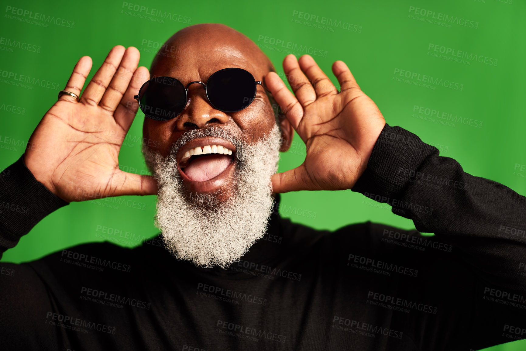 Buy stock photo Studio shot of a senior man wearing glasses and making funny faces against a green background