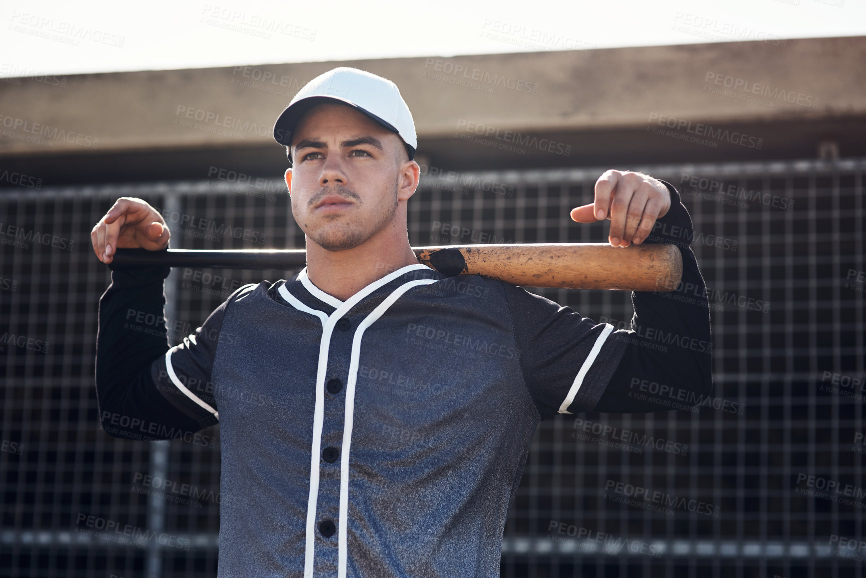 Buy stock photo Shot of a young man holding his bat at a baseball game