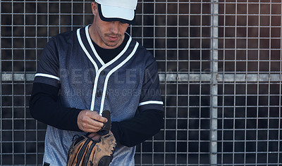 Buy stock photo Shot of a young man putting on his mitt at a baseball game