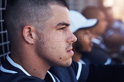 Buy stock photo Shot of a young man watching a baseball game with his team mates