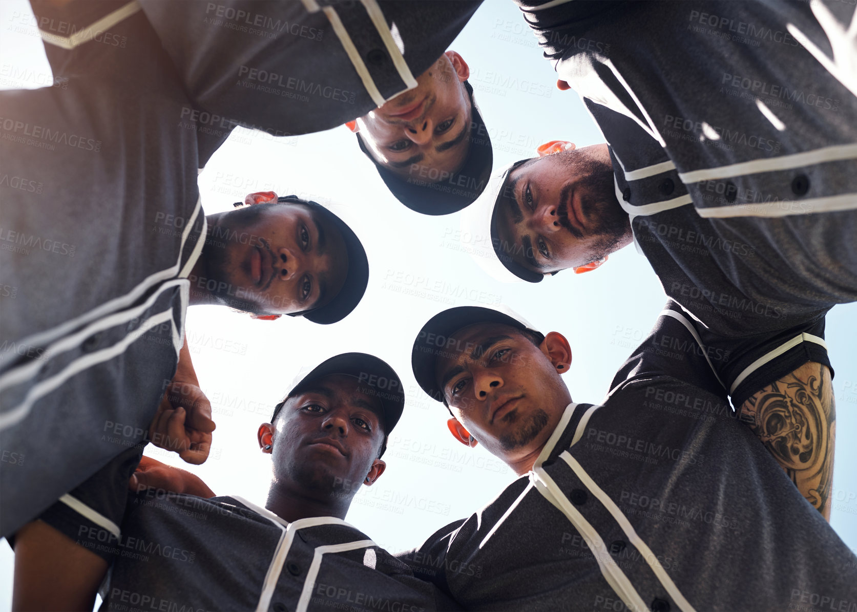Buy stock photo Low angle shot of a group of young men huddled together at a baseball game