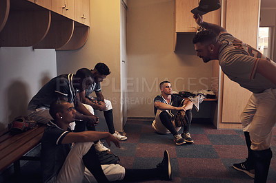 Buy stock photo Shot of a young man yelling at his fellow baseball players in a locker room.