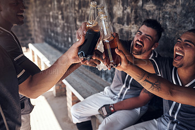 Buy stock photo Shot of a group of young men celebrating with drinks after playing a baseball game