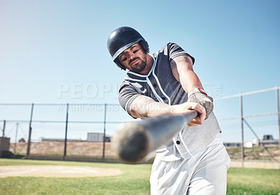 Buy stock photo Shot of a young man swinging his bat at a baseball game