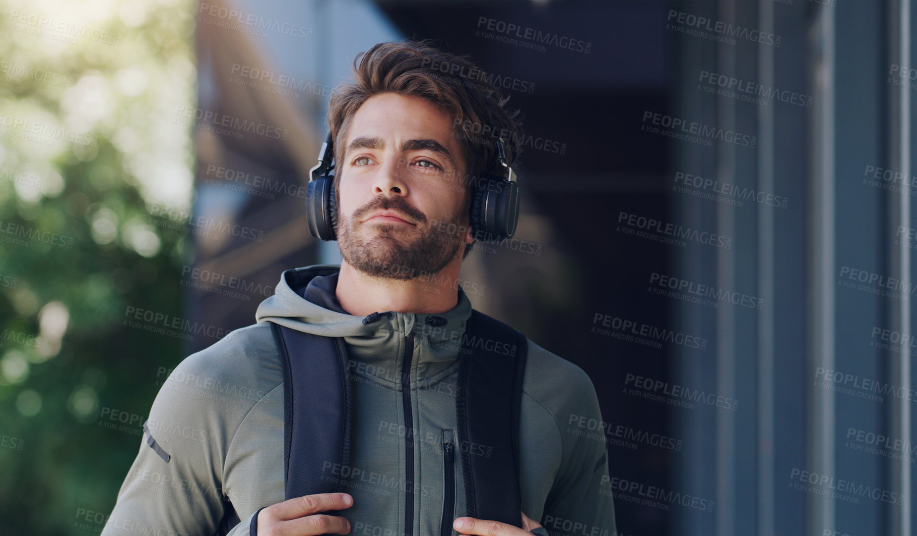 Buy stock photo Cropped shot of a young man wearing headphone while walking through the city