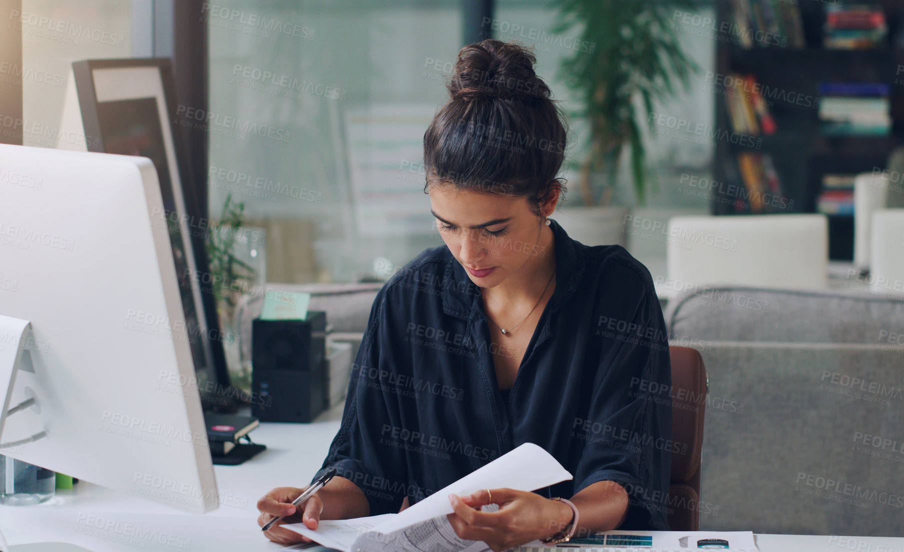 Buy stock photo Cropped shot of an attractive young businesswoman working on paperwork in her office
