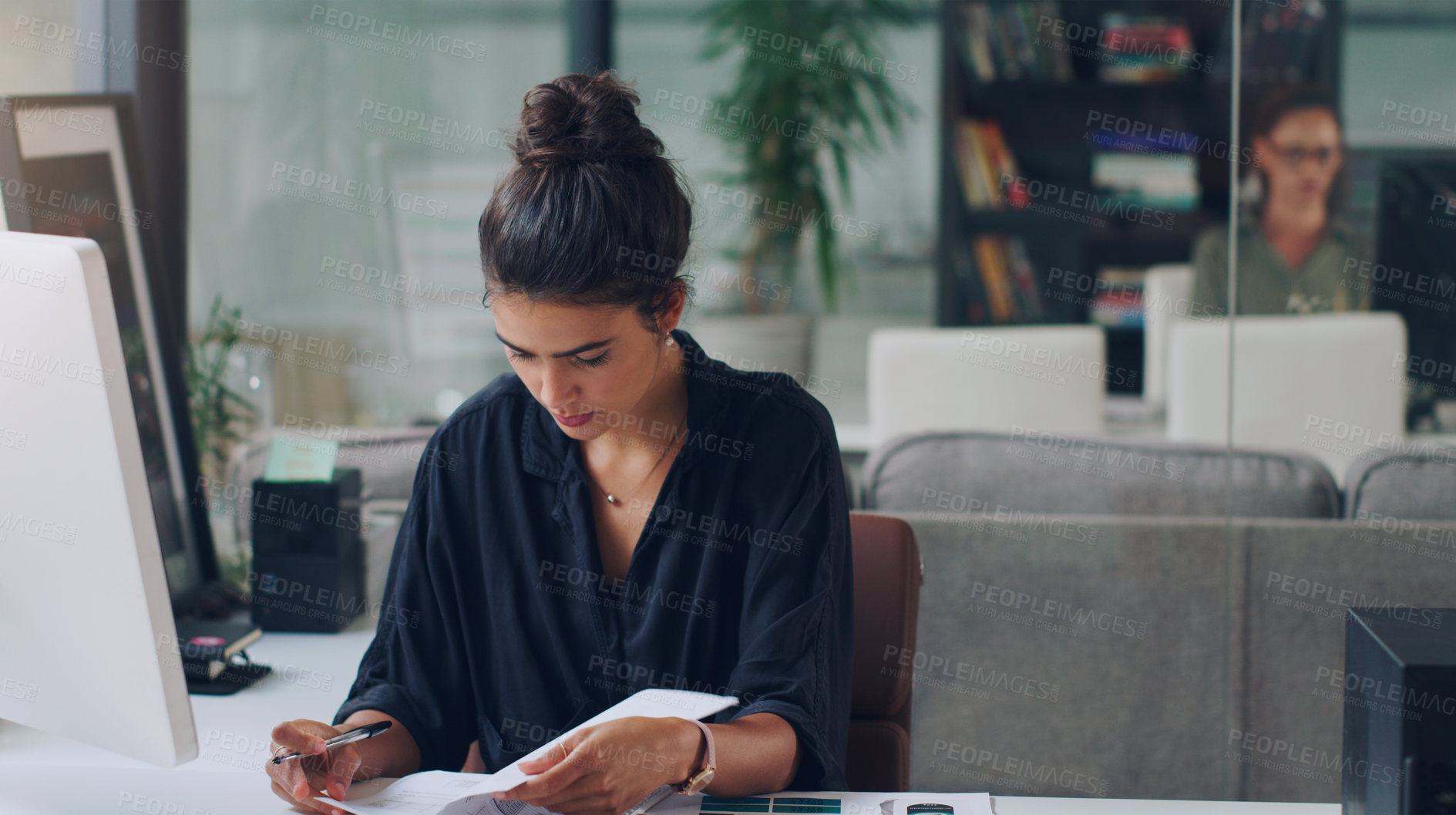 Buy stock photo Cropped shot of an attractive young businesswoman working on paperwork in her office