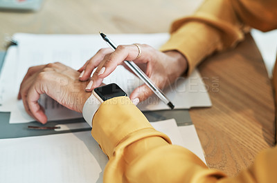 Buy stock photo Closeup shot of an unrecognisable businesswoman checking her wristwatch while writing notes in an office