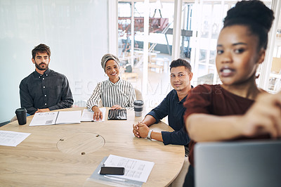 Buy stock photo Shot of a group of businesspeople listening to a presentation from a colleague in an office