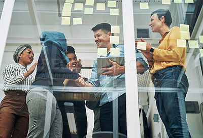 Buy stock photo Shot of a group of businesspeople applauding their colleagues while brainstorming on a glass wall in an office