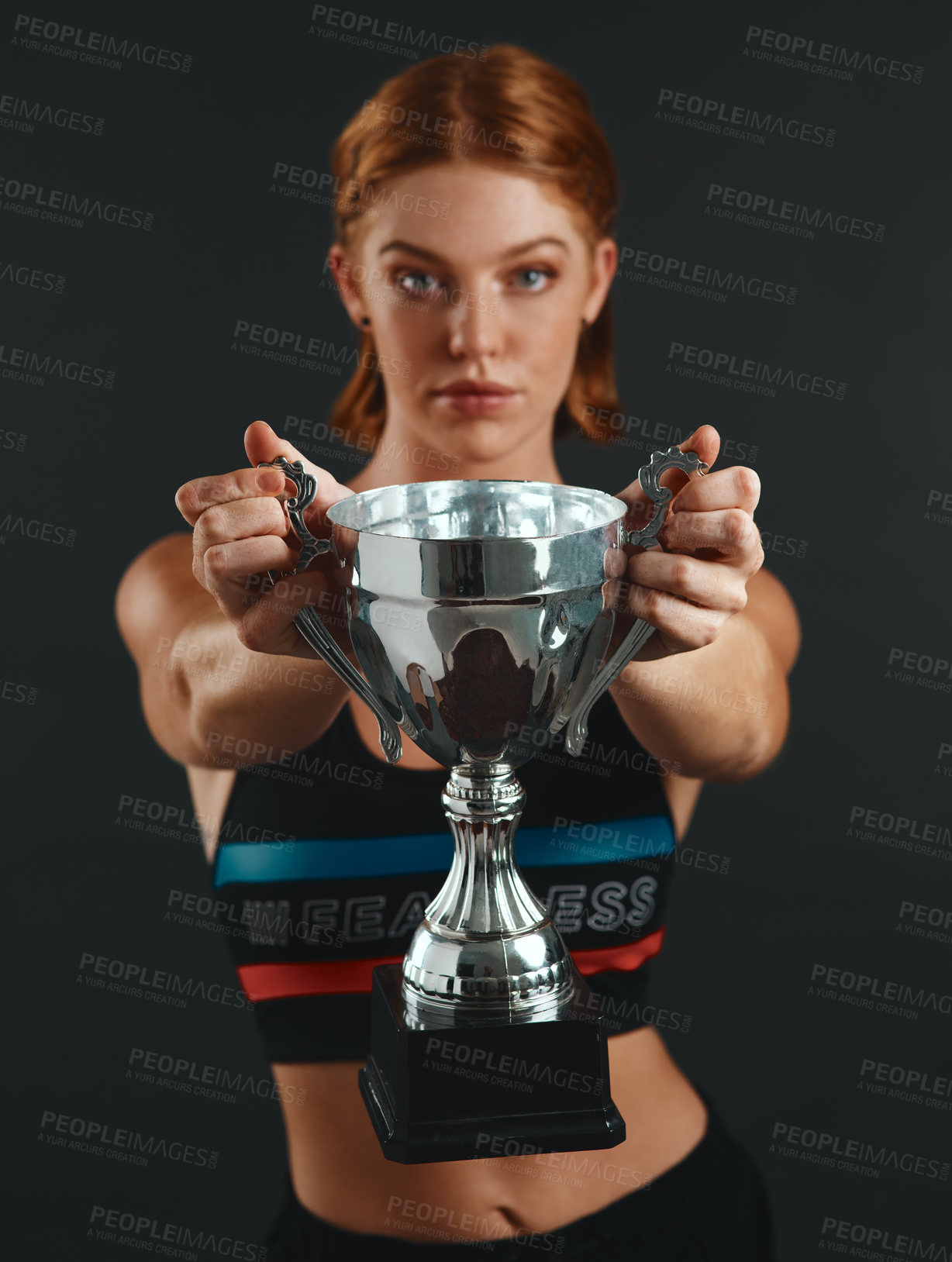 Buy stock photo Woman, sports and trophy in studio on portrait for winning, victory and success at competition on grey background. Female person, athlete and serious on confidence with cup for completing tournament