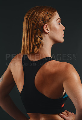 Buy stock photo Studio shot of a sporty young woman posing against a black background