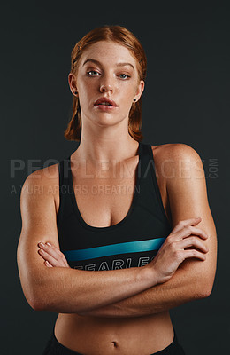 Buy stock photo Studio portrait of a sporty young woman posing against a black background
