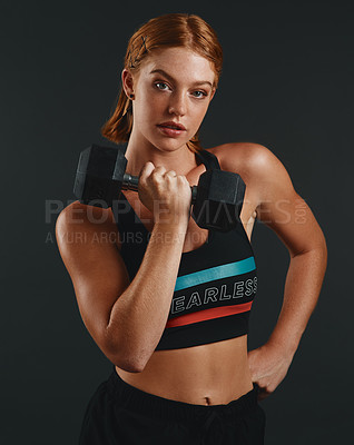 Buy stock photo Studio portrait of a sporty young woman exercising with a dumbbell against a black background