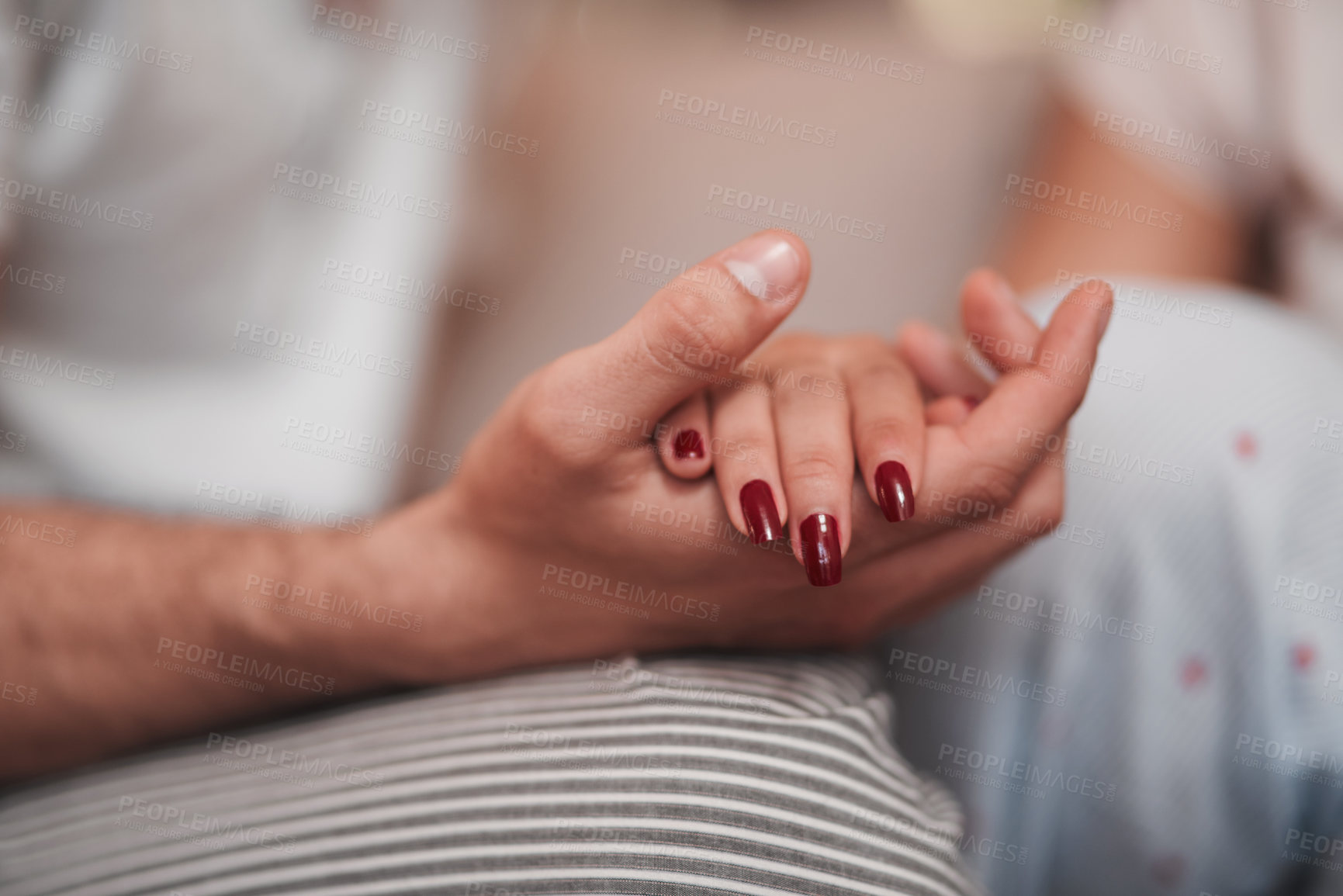 Buy stock photo Cropped shot of an unrecognizable couple holding hands affectionately at home
