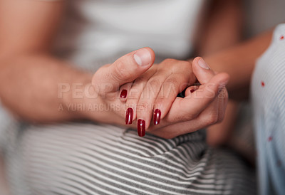 Buy stock photo Cropped shot of an unrecognizable couple holding hands affectionately at home
