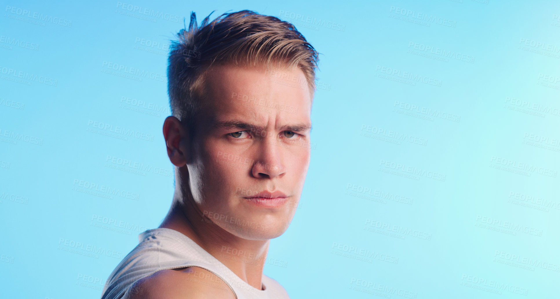 Buy stock photo Studio portrait of a handsome young man posing against a blue background