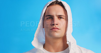 Buy stock photo Studio portrait of a handsome young man posing in a hooded sweater against a blue background