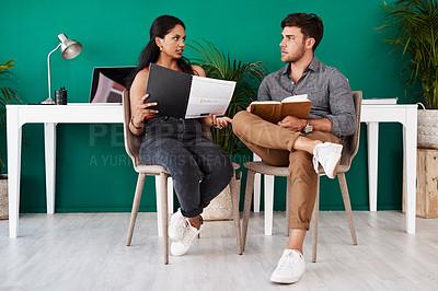 Buy stock photo Shot of two young designers having a discussion in an office