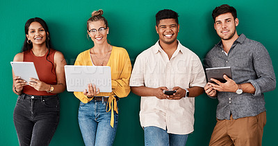 Buy stock photo Portrait of a group of young designers using digital devices while standing together against a green background