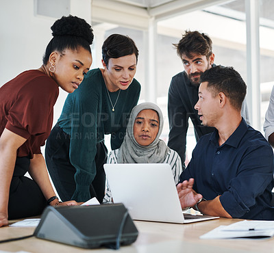 Buy stock photo Shot of a group of businesspeople using a laptop during a meeting in a modern office