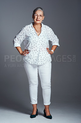 Buy stock photo Studio shot of a senior woman posing against a gray background