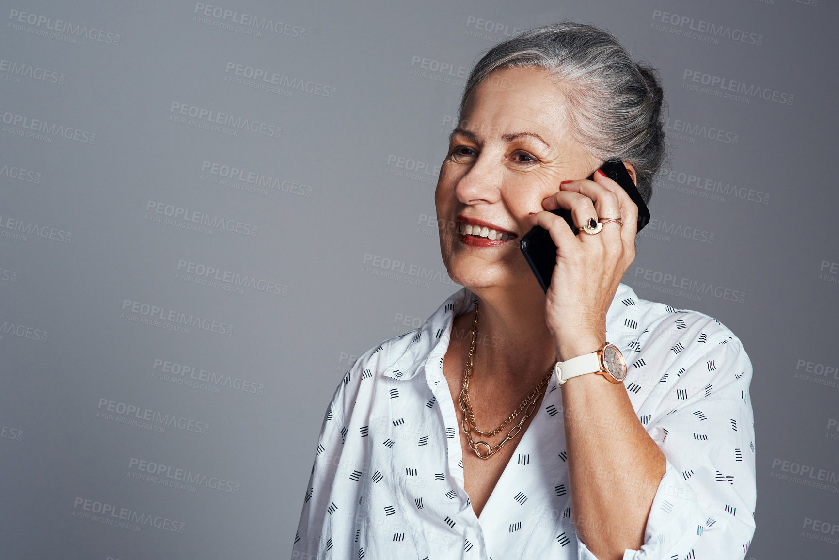 Buy stock photo Studio shot of a senior woman talking on her cellphone against a grey background
