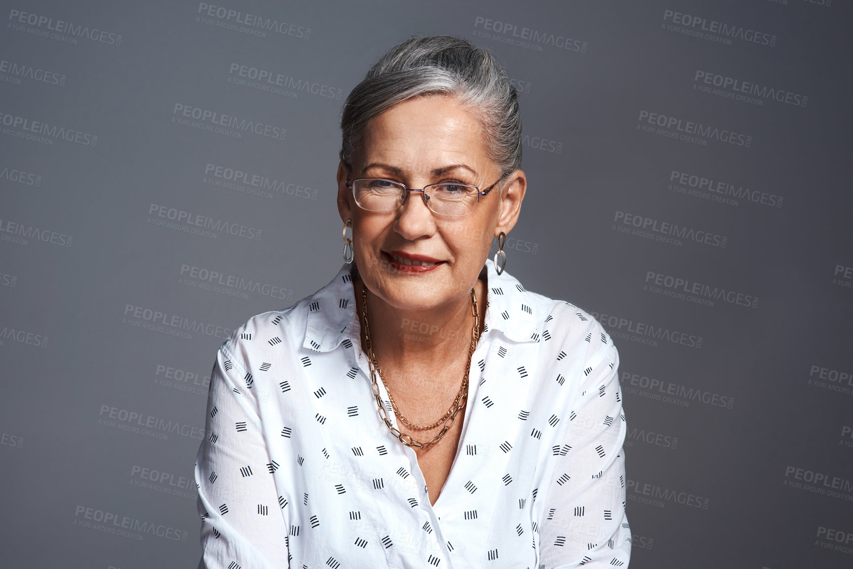 Buy stock photo Studio shot of a senior woman posing against a gray background