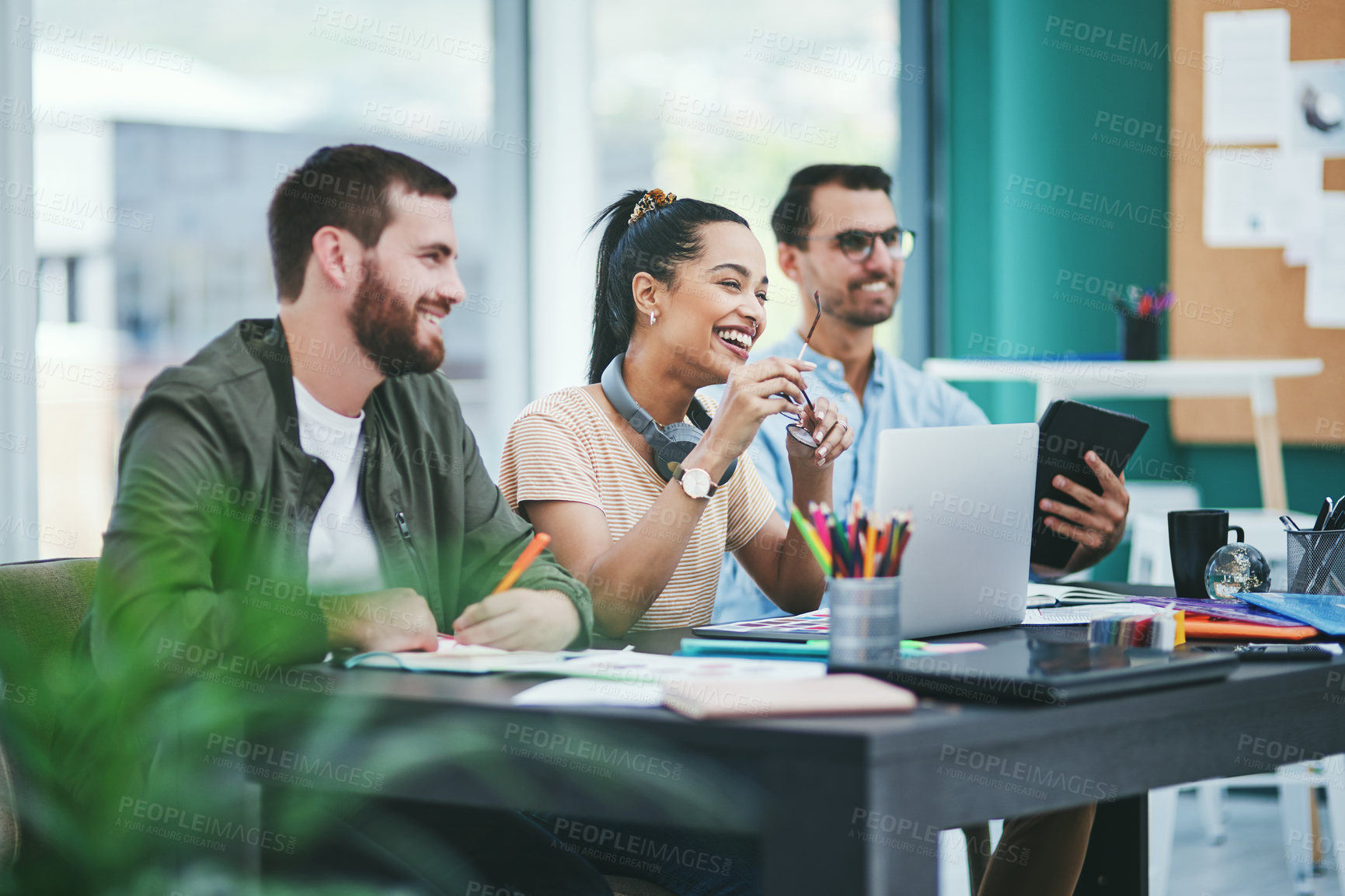 Buy stock photo Shot of a group of young designers listening to a presentation in an office