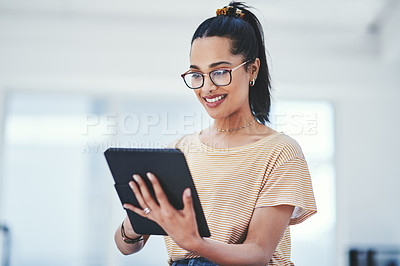 Buy stock photo Shot of a young designer using a digital tablet in an office