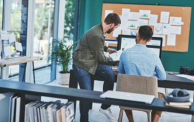 Buy stock photo Rearview shot of two young designers working together in an office