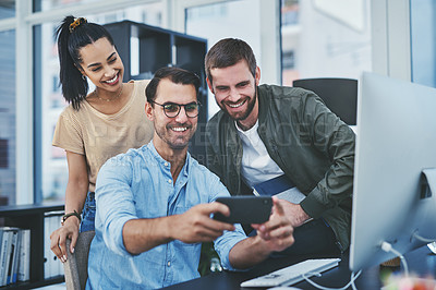 Buy stock photo Happy, business people and selfie with team at office desk for picture, memory or photography together. Young, group or employees with smile in joy for moment, capture or social media at workplace