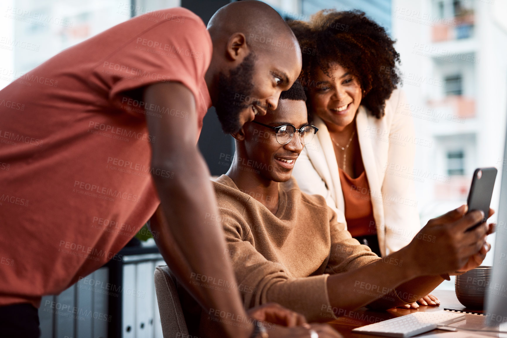 Buy stock photo Shot of a man showing his colleagues something on his cellphone