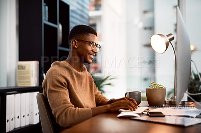Buy stock photo Cropped shot of a young businessman using his computer while sitting at his desk