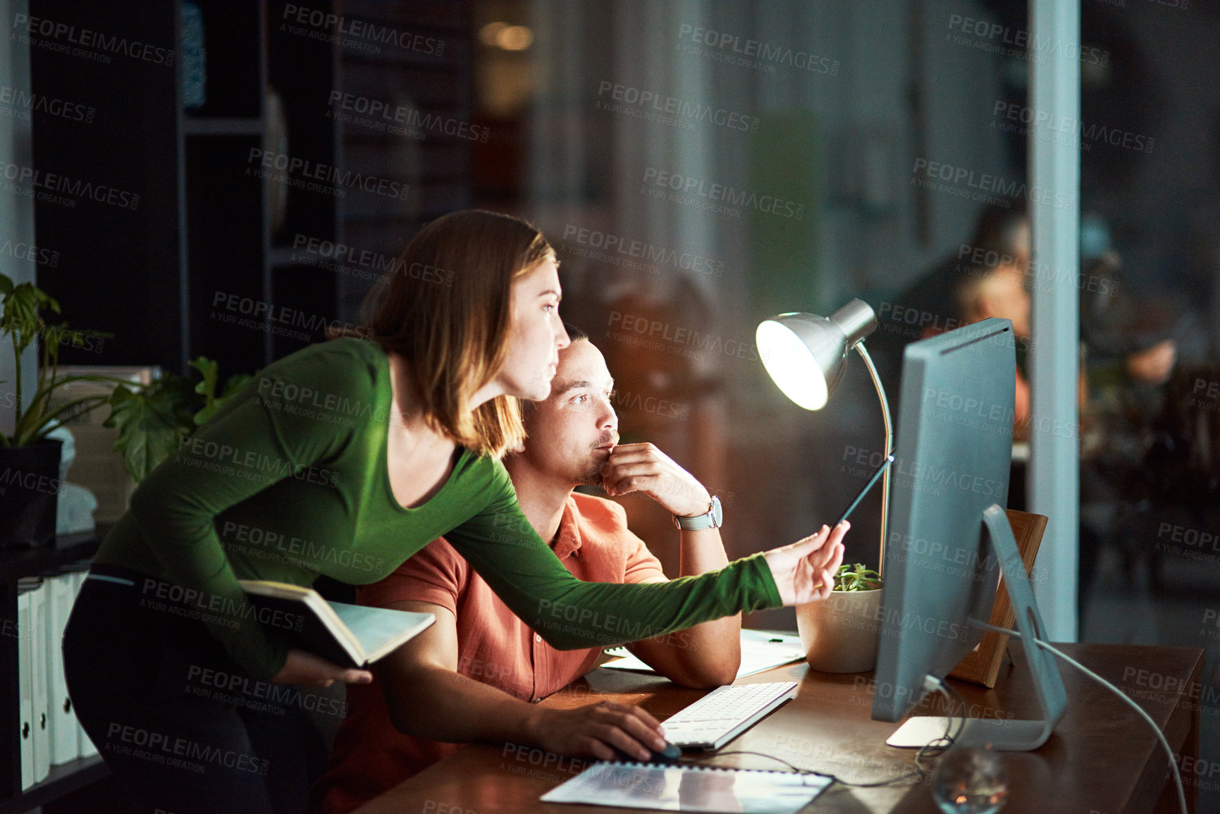 Buy stock photo Cropped shot of two young designers working together at night