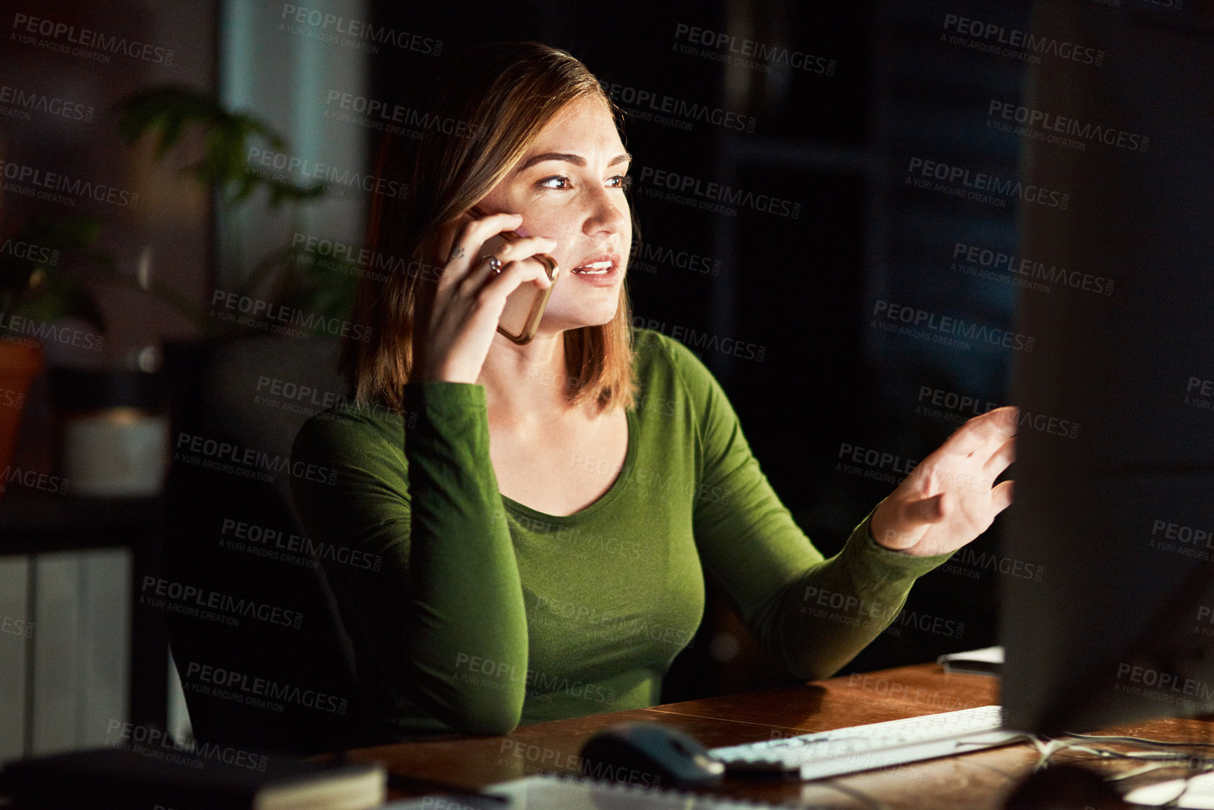 Buy stock photo Shot of a woman talking on her cellphone while working late at the office