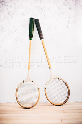 Buy stock photo Shot of two squash racquets leaning against the wall in a squash court
