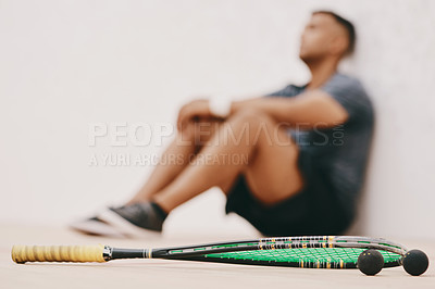 Buy stock photo Shot of a young man taking a break after playing a game of squash