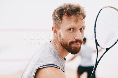 Buy stock photo Portrait of a young man playing a game of squash with his team mate in the background