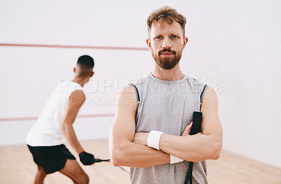 Buy stock photo Portrait of a young man playing a game of squash with his team mates in the background