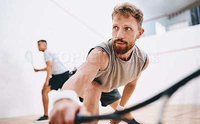Buy stock photo Shot of two young men playing a game of squash