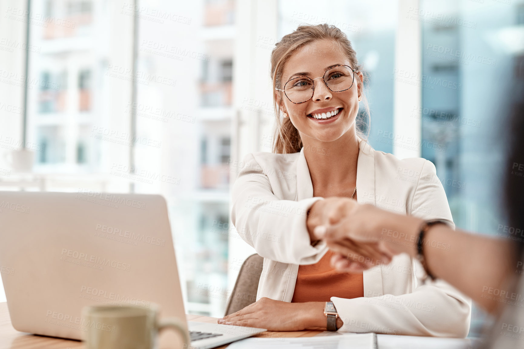 Buy stock photo Cropped shot of an attractive young businesswoman shaking hands with an unrecognizable colleague during a meeting in the boardroom