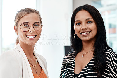 Buy stock photo Cropped portrait of two attractive young businesswomen standing in their office